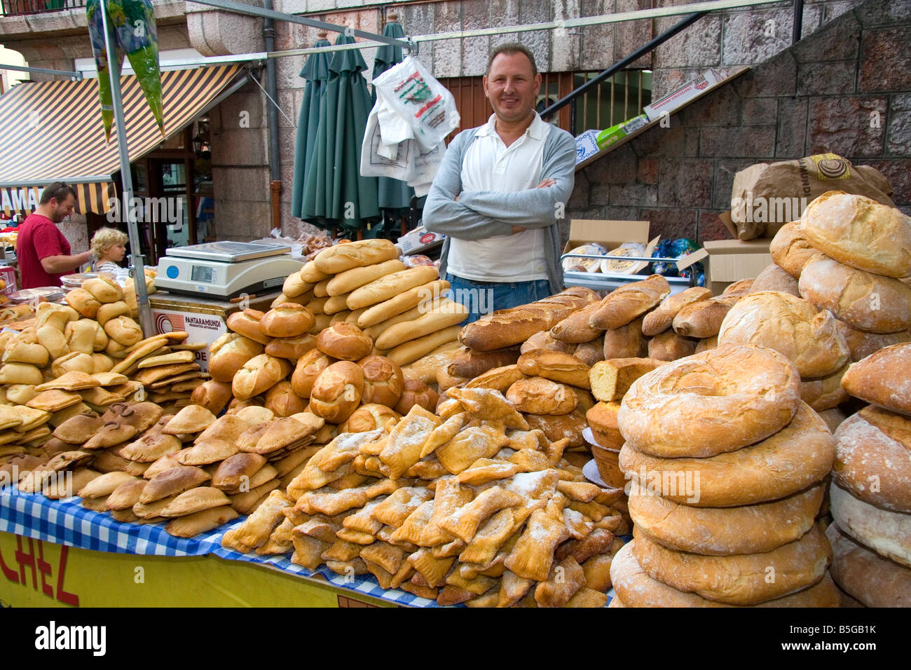 Venditore a vendere pane e prodotti da forno in un mercato all'aperto nella città di Cangas de Onis Asturias Spagna settentrionale Foto Stock