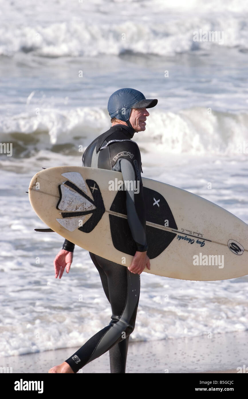Surfer con tavola da surf tutto è pensato per il suo rituale mattutino ho Foto Stock