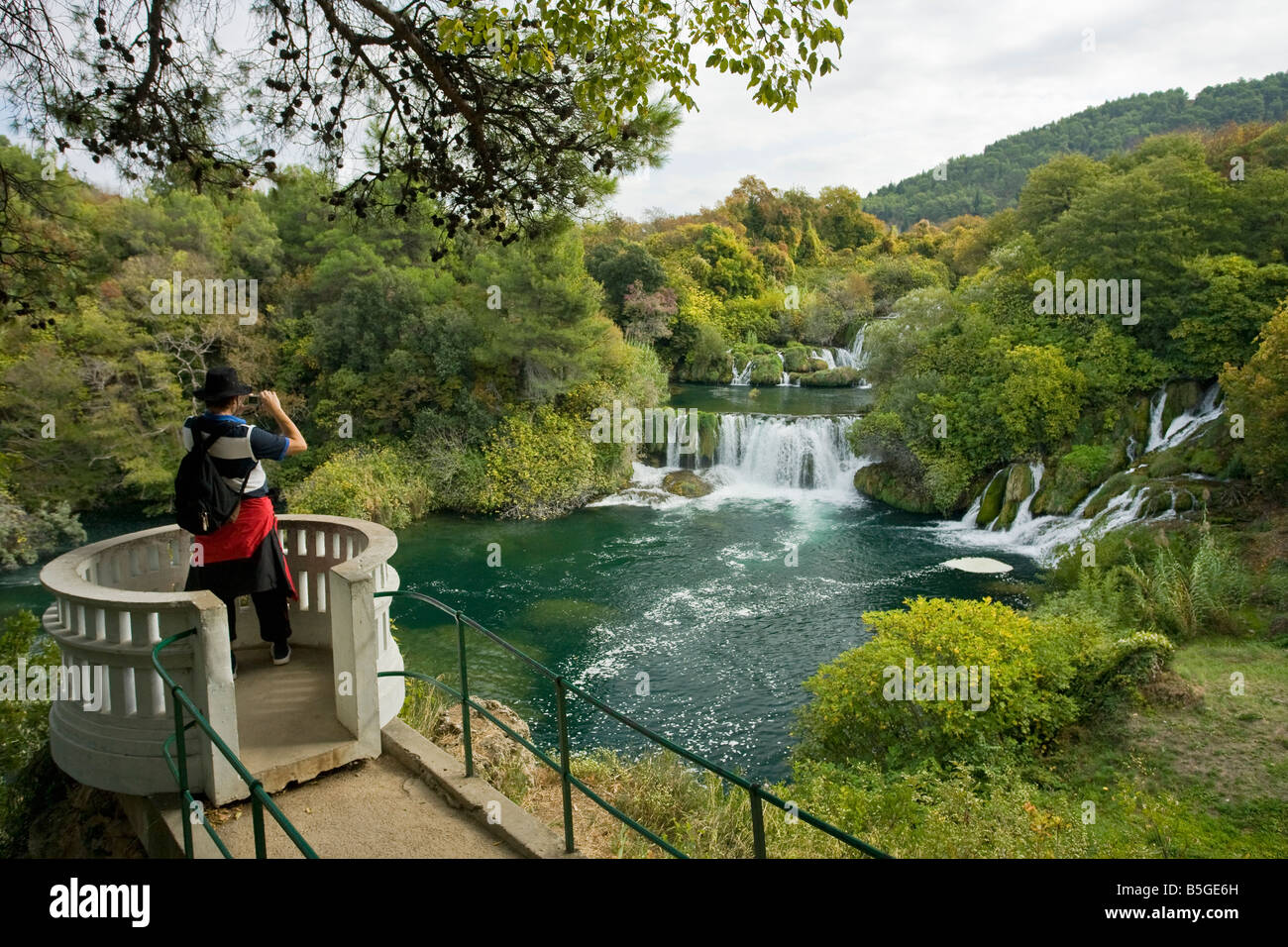 Giovane uomo prendendo la foto del Skradinski Buk cascate del fiume Krka in autunno sole Parco Nazionale di Krka Dalmazia Croazia Foto Stock