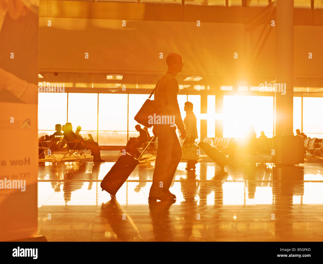 Viaggiatore con bagaglio a piedi l'aeroporto concourse a sunrise Foto Stock