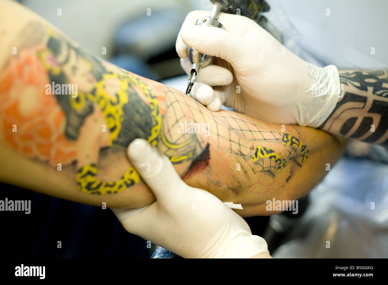 L'uomo avente il suo braccio tatuato. Foto Stock
