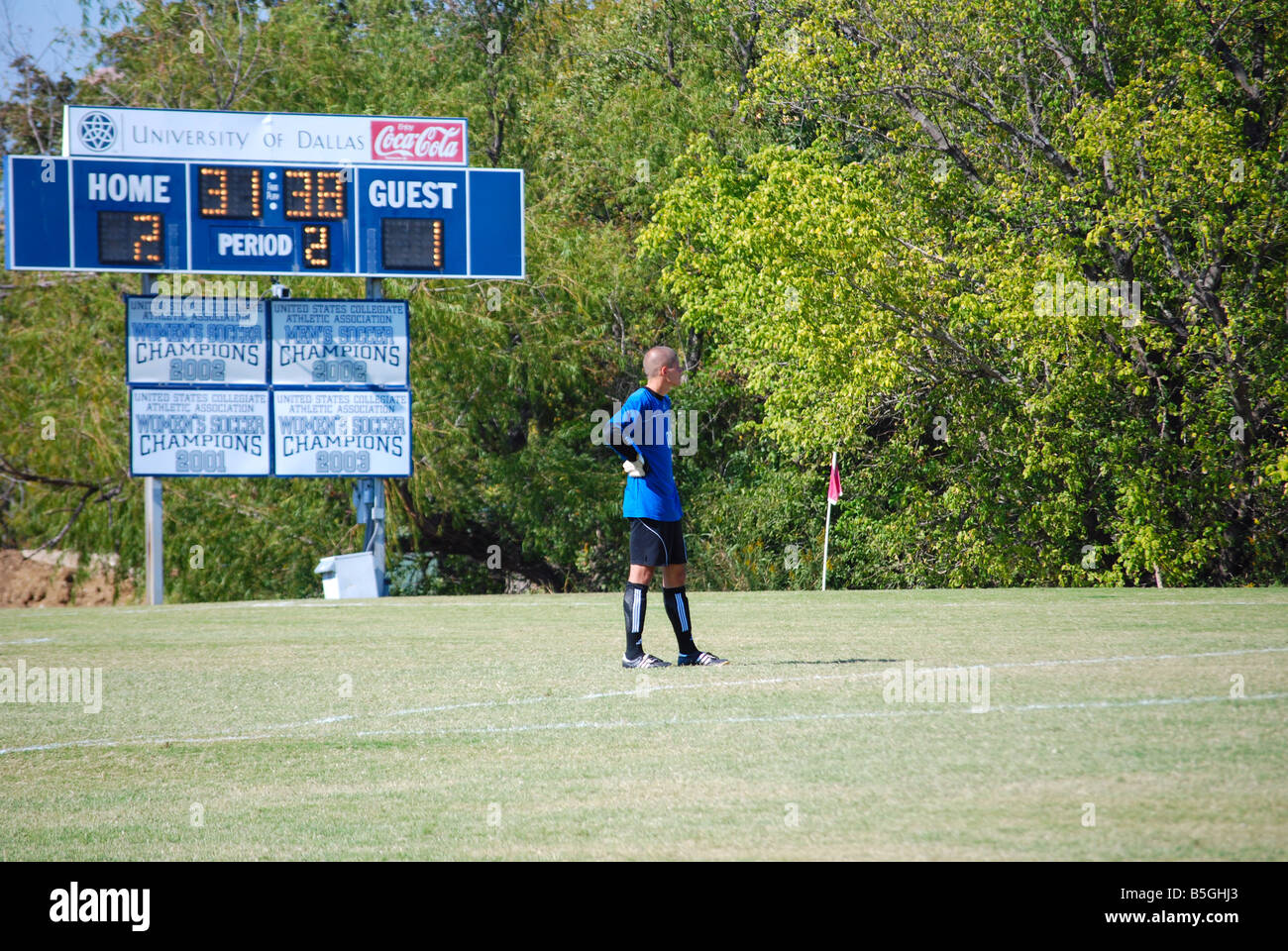 College soccer goalie guardando downfield azione (scoreboard in background) Foto Stock