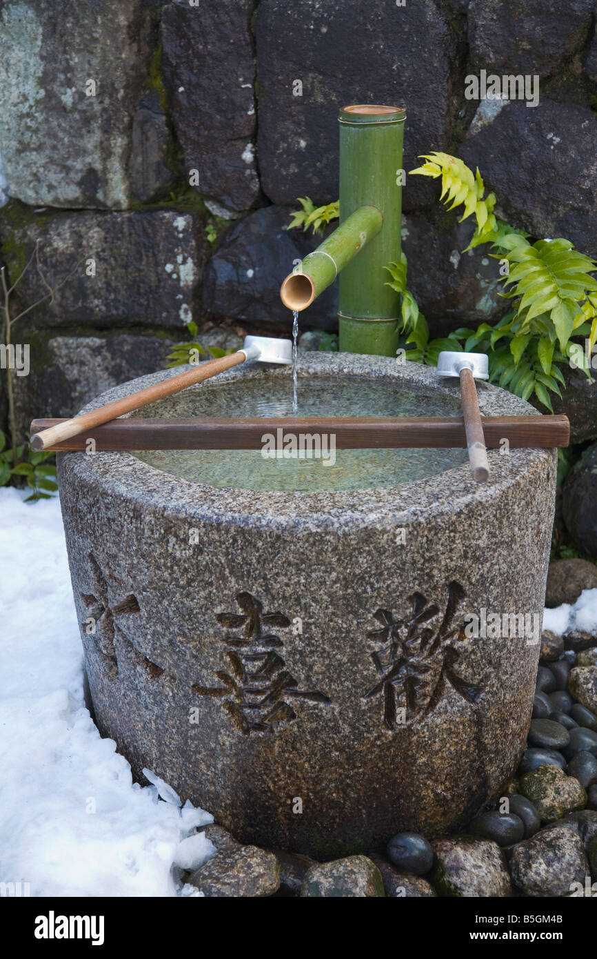 La città di Kyoto Giappone tempio di Kiyomizu bamboo mestoli in appoggio sul rack hishaku oltre un chuzua lavaggio rituale trogolo di acqua Foto Stock