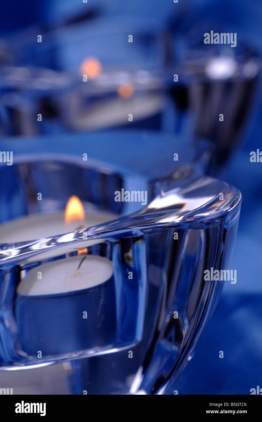 Coppia di candele in un candelieri in vetro blu sullo sfondo di seta Foto Stock