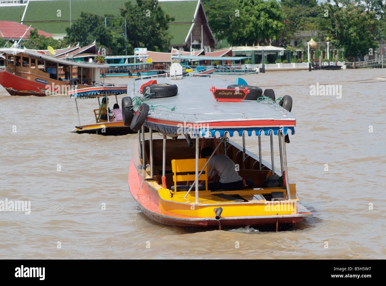 Piccoli traghetti per passeggeri e un rimorchiatore a traino sul Fiume Chao Praya river a Bangkok in Tailandia Foto Stock