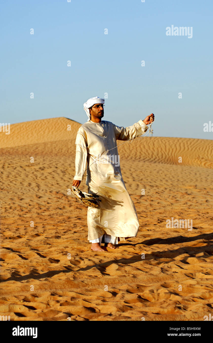 Arab falconer cerca di attirare il suo falcone da caccia con un manichino preda Dubai Emirati Arabi Uniti EMIRATI ARABI UNITI Foto Stock