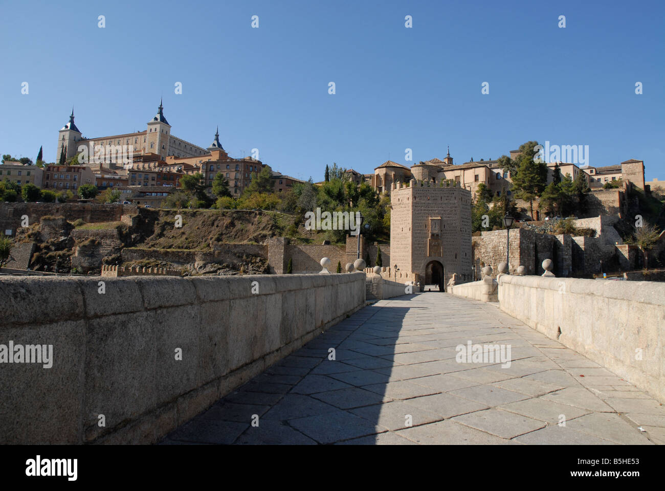 Vista attraverso il Puente de Alcantara alla città di Toledo, Castilla-la Mancha, in Spagna Foto Stock