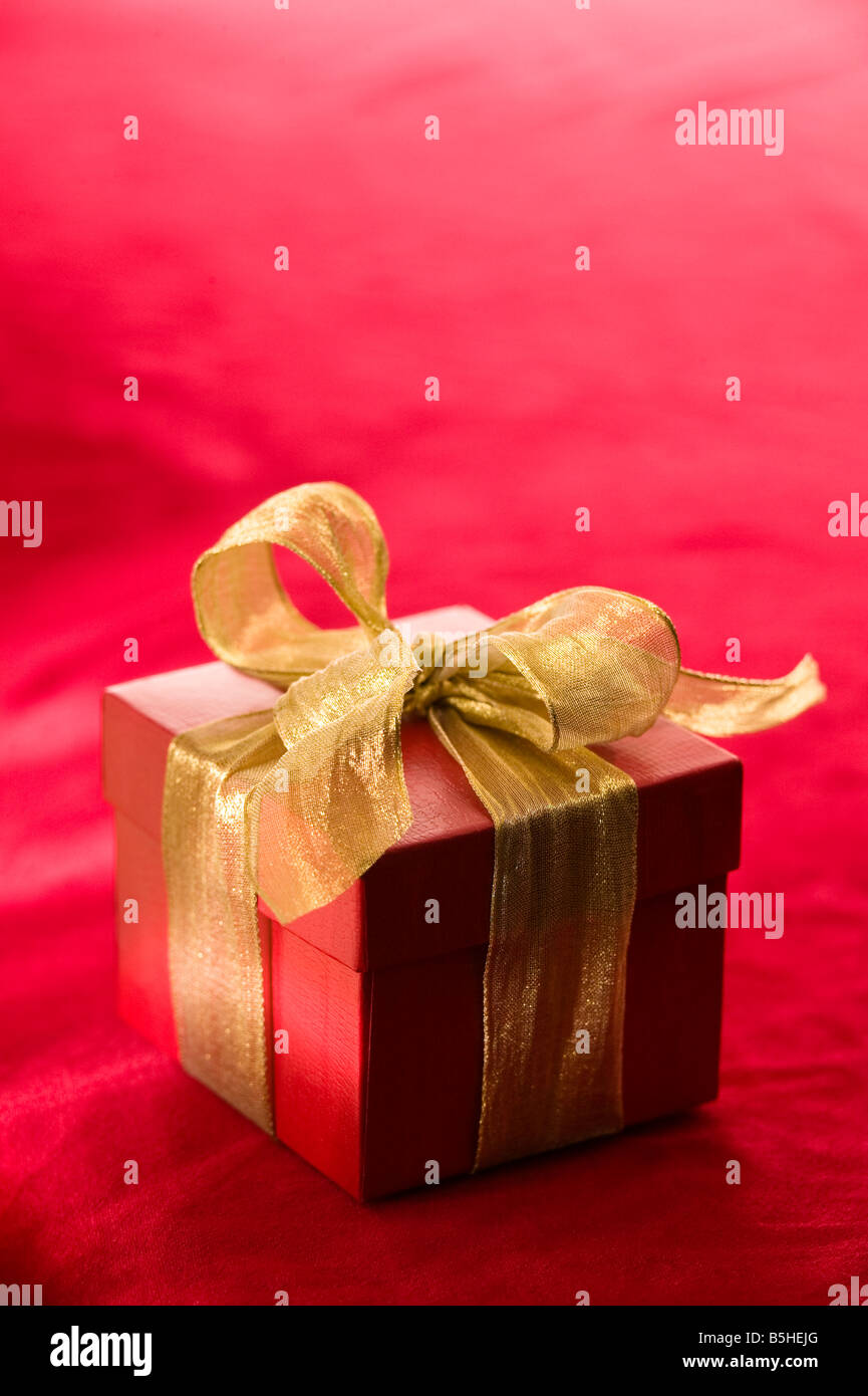 Confezione regalo rossa con un elemento metallico nastro color oro Foto Stock