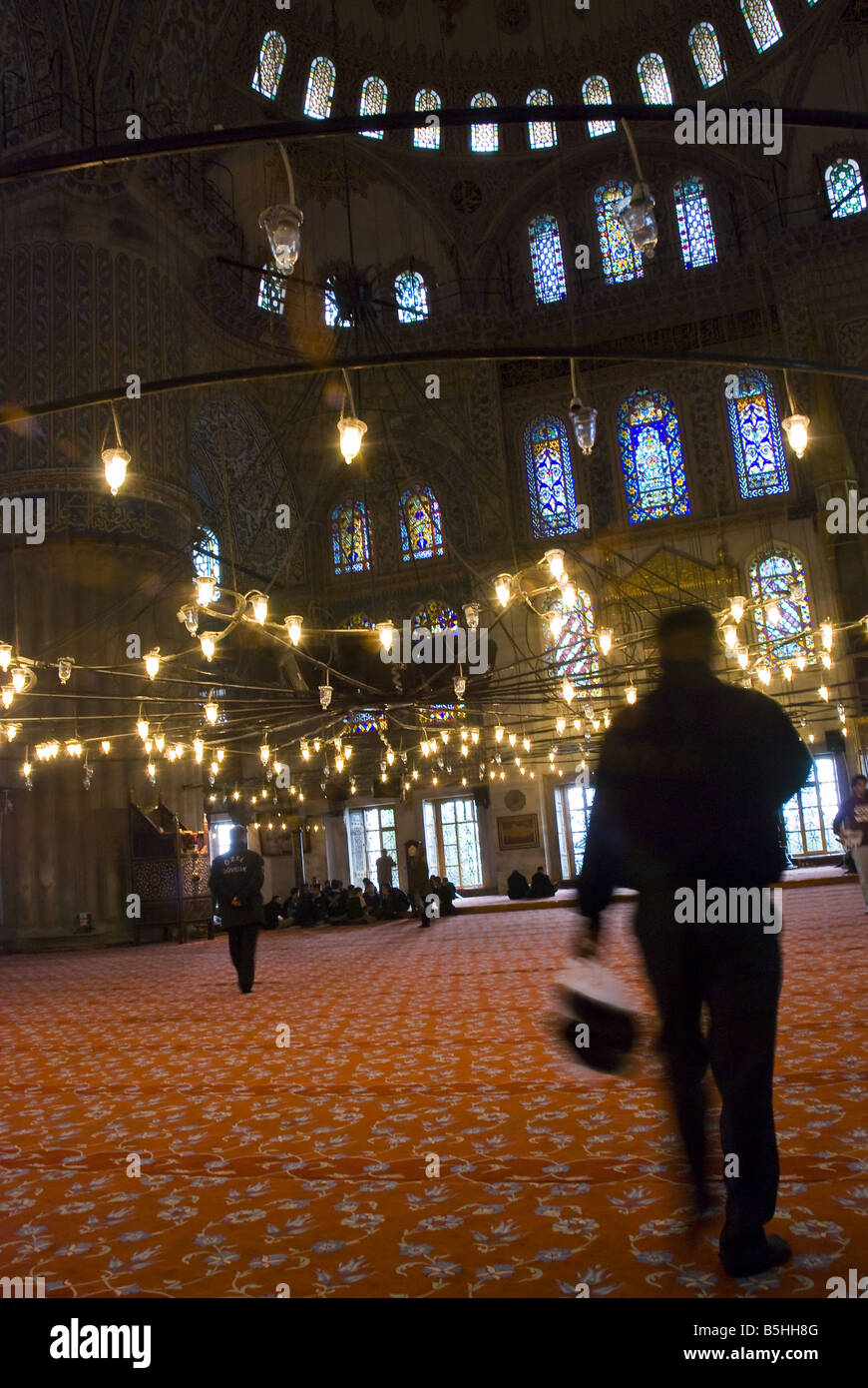 Un adoratore porta le sue scarpe in un sacchetto di plastica nella moschea blu a Istanbul, Turchia. Foto Stock
