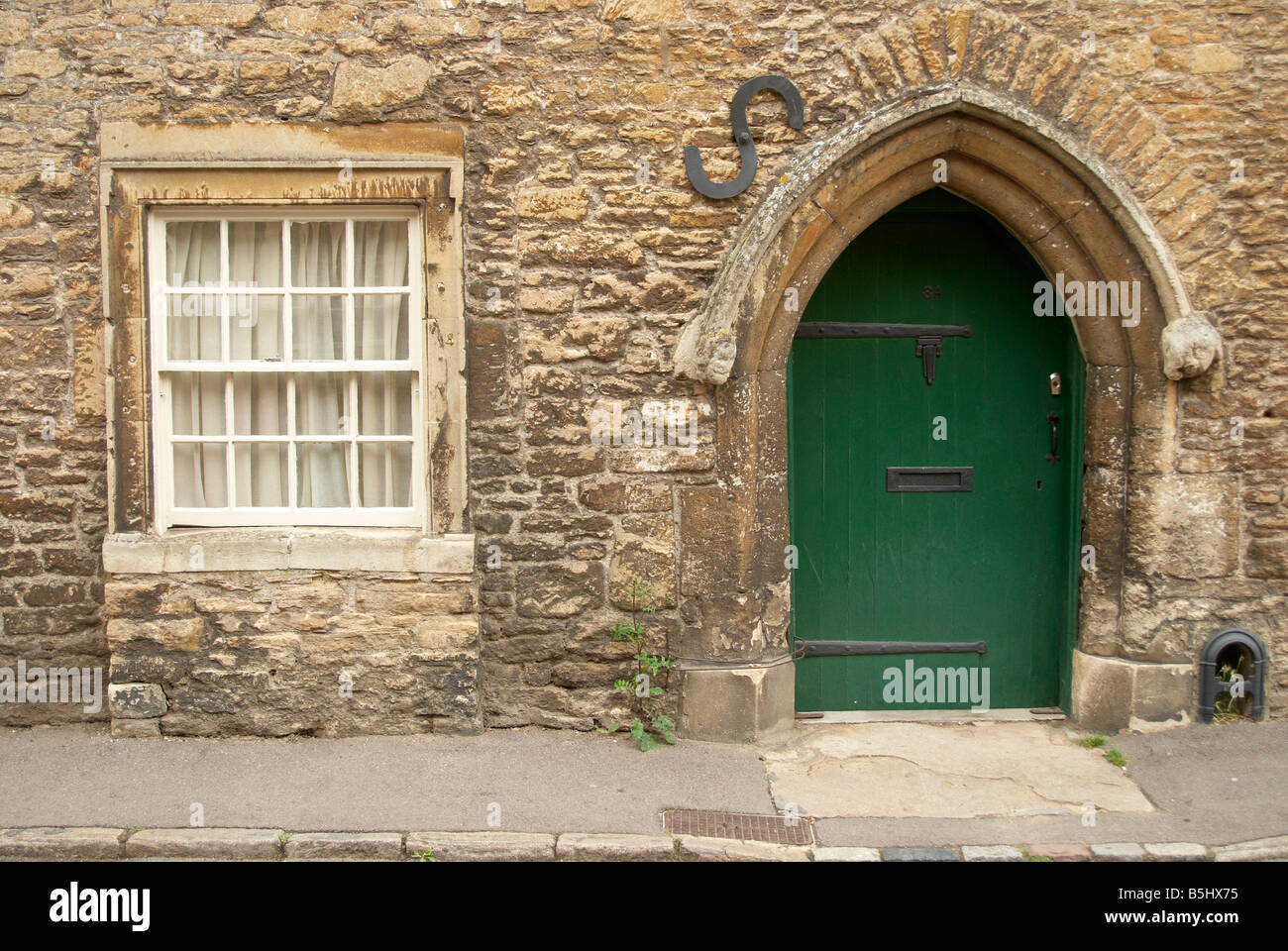 Contrasto di stili architettonici - porta e finestra in un cottage in Lacock, Wiltshire, Inghilterra Foto Stock