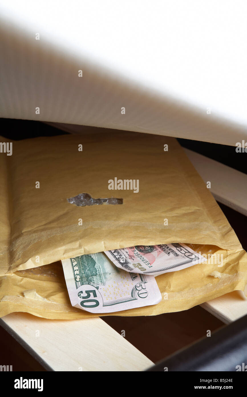 wad di 50 dollari us dollari banconote contanti in una busta farcita sotto il materasso di un letto Foto Stock