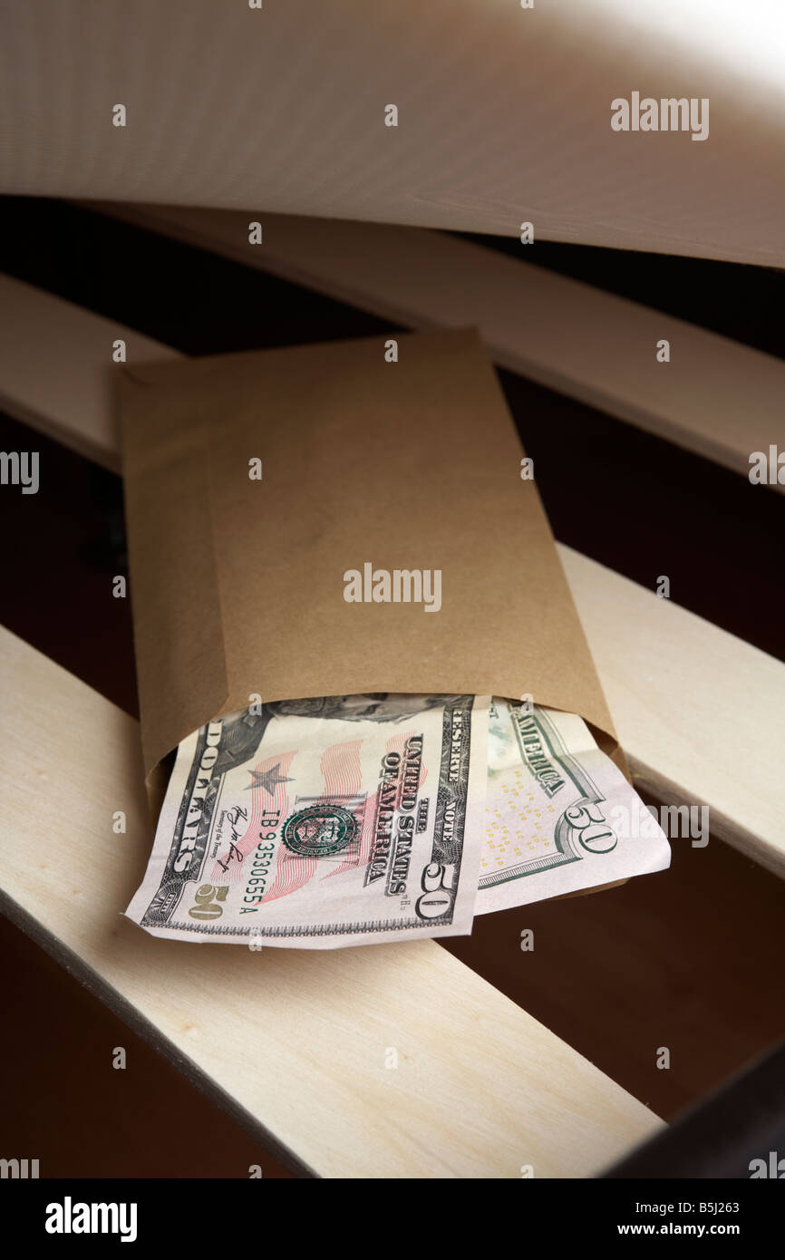 Borra di noi 50 dollar note di contanti in una busta ripiene sotto il materasso di un letto Foto Stock