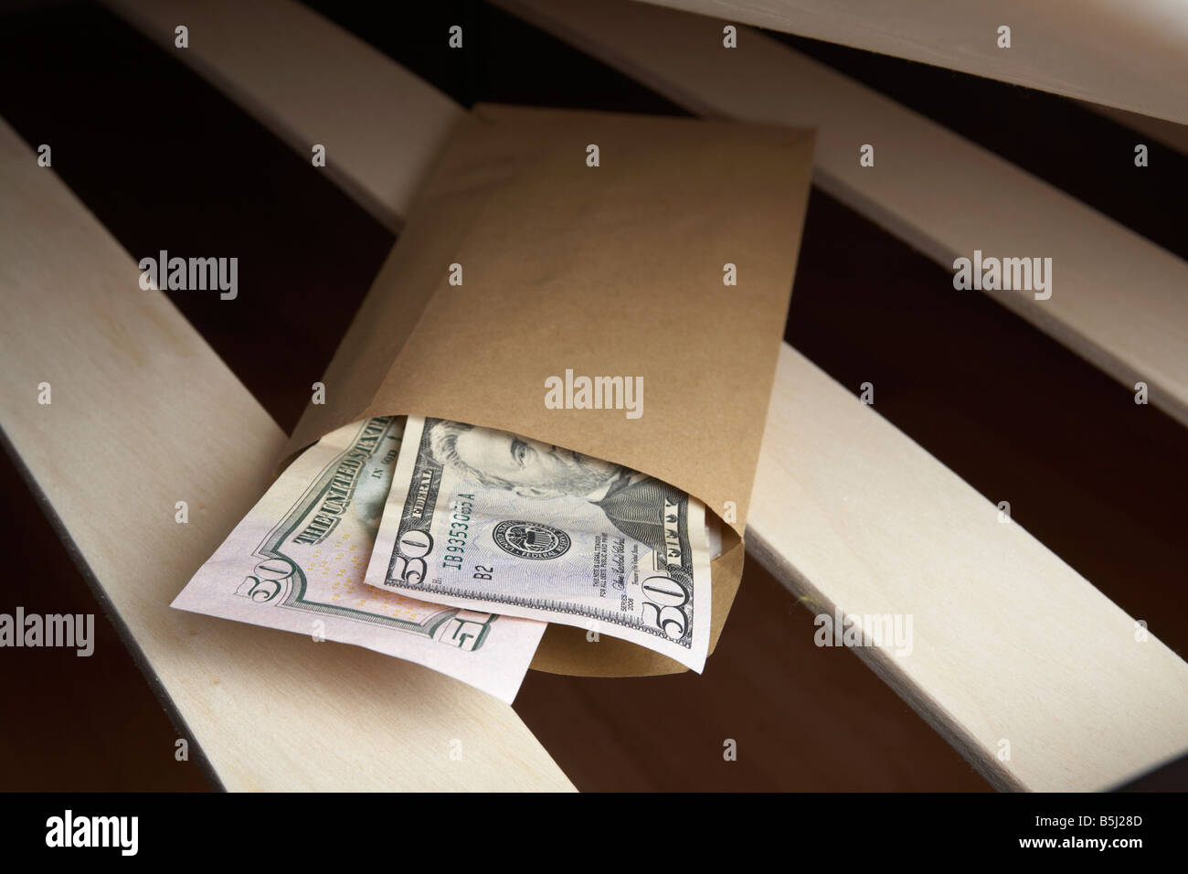Borra di noi 50 dollar note di contanti in una busta ripiene sotto il materasso di un letto Foto Stock