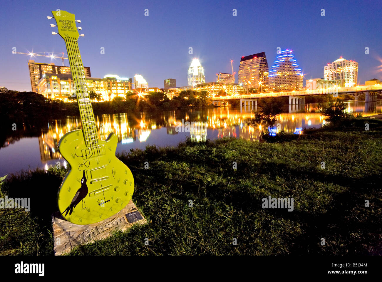 Vista del centro di Austin da Riverside in città sul lago con uno dei dipinti Austin City Limits chitarre in primo piano Foto Stock