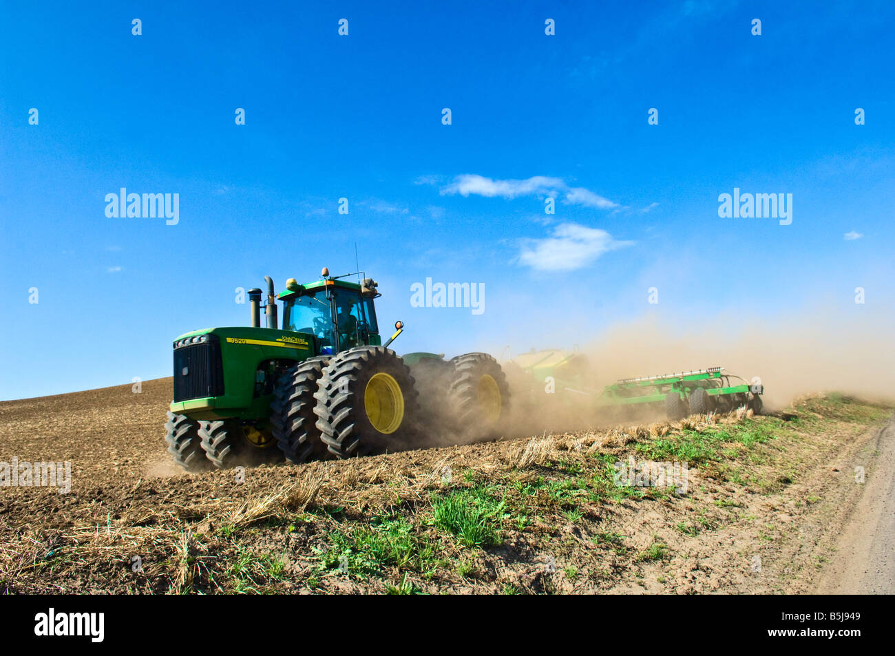 Un trattore tira una seminatrice ad aria per l'impianto di cereali o legumi in primavera nella regione Palouse di Washington Foto Stock