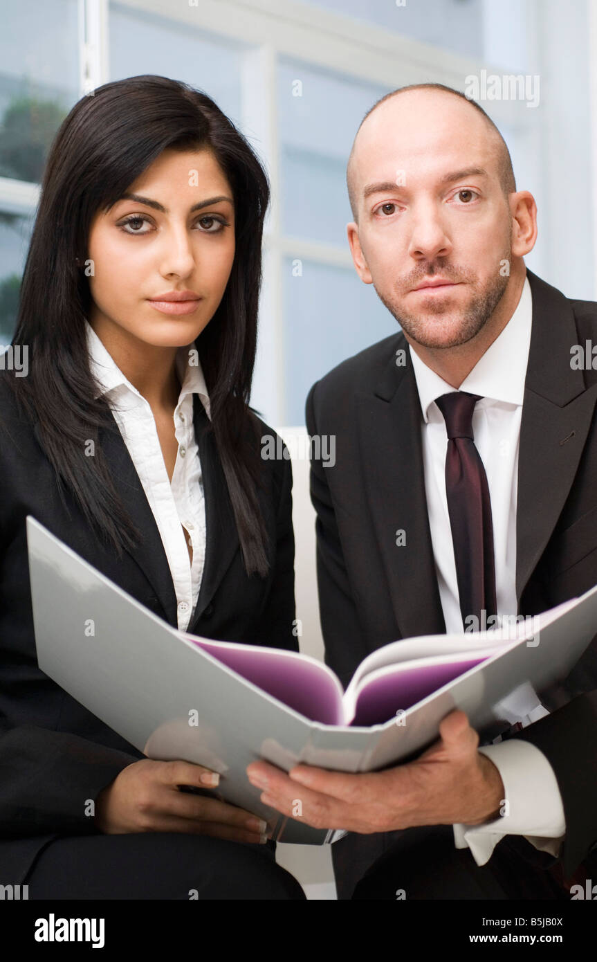 Imprenditrice e collega di sesso maschile seduti insieme documento di lettura Foto Stock