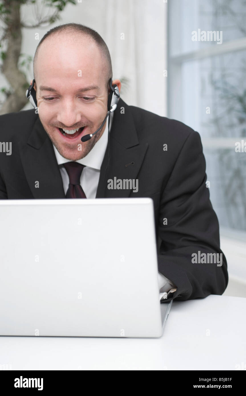 Ritratto di imprenditore che indossa la cuffia funziona con computer portatile Foto Stock