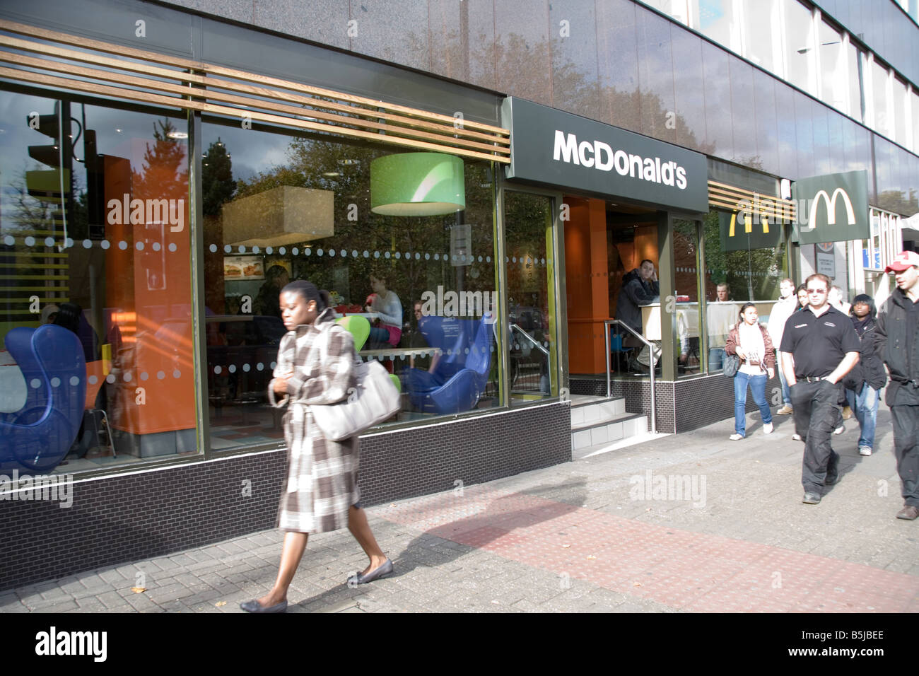 Persone in seduta e camminare da McDonald s in Upper Street islington Foto Stock