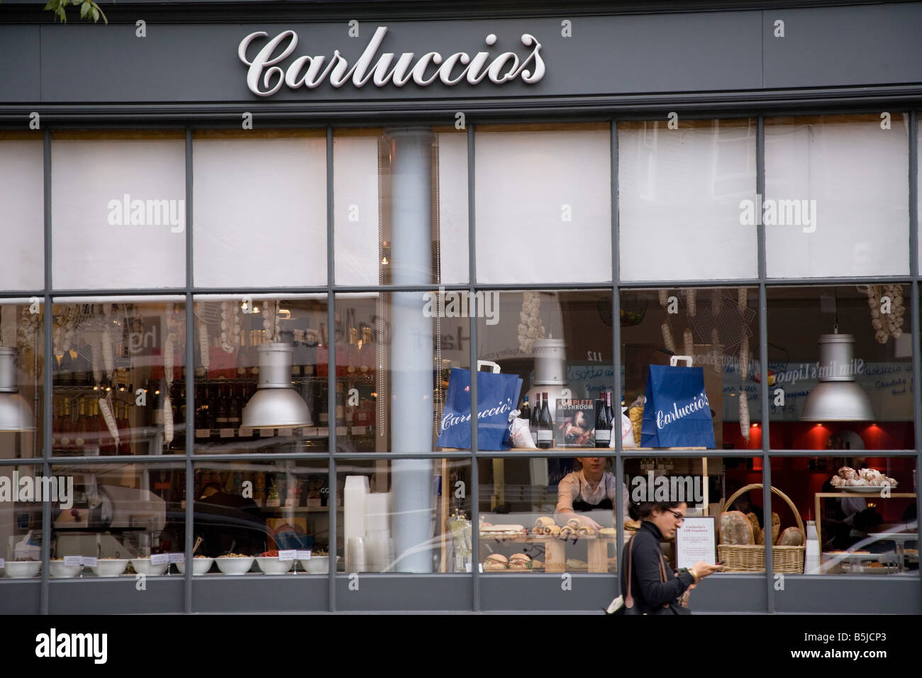 La donna in piedi davanti di Carluccio s shopfront Upper Street Islington Londra Foto Stock