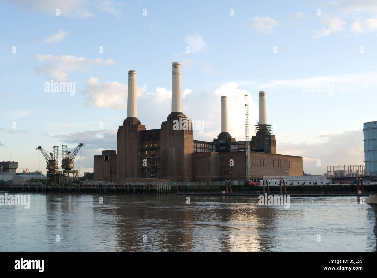 Una vista di fronte del tamigi guardando Battersea Power Station che si riflette nel Tamigi con cielo blu sopra Foto Stock