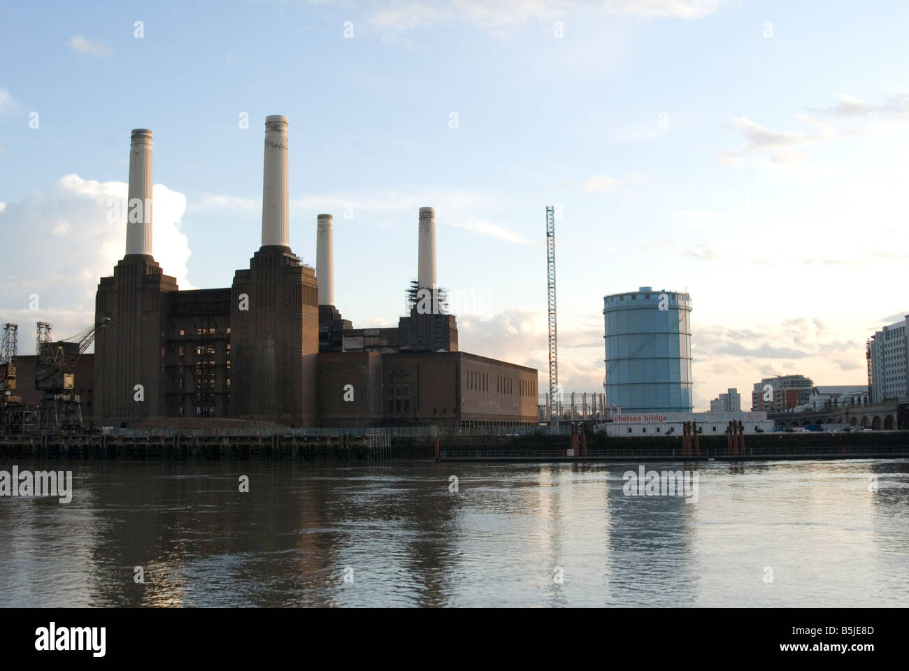 Una vista di fronte del tamigi guardando Battersea Power Station che si riflette nel Tamigi come il sole comincia a impostare Foto Stock