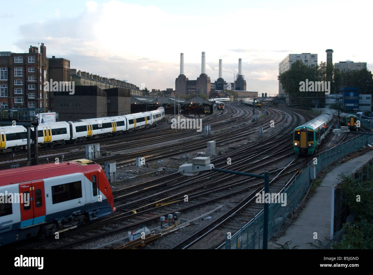 Un'immagine di 3 treni sulle vie che conducono alla stazione Victoria con Battersea Power Station in background Foto Stock