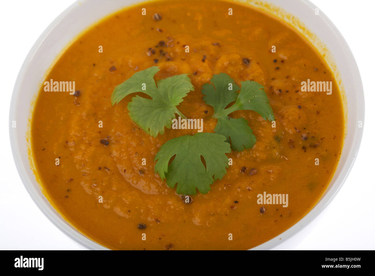 Ciotola di carota organico e coriandolo zuppa con foglie di coriandolo fresco Foto Stock