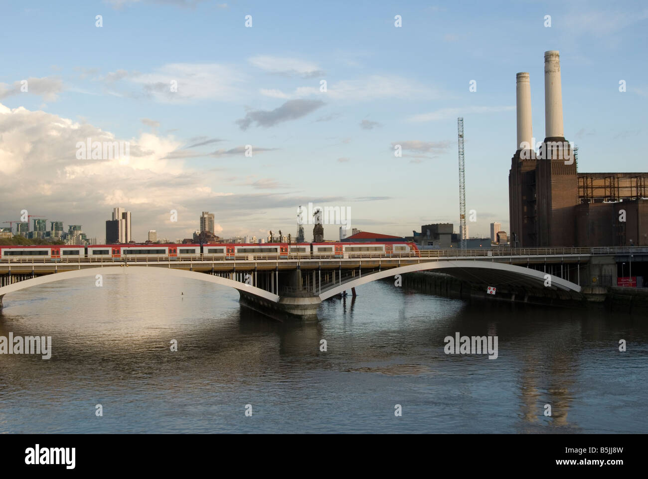 Un'immagine del ponte della ferrovia che va oltre il Tamigi da Battersea verso Victoria. Battersea Power Station è dietro. Foto Stock