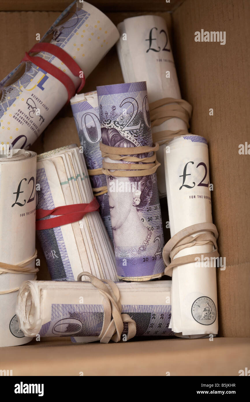 Mazzette di 20 sterline Bank of England notes cash legati a rotoli di nastro elastico nascosto in una scatola di cartone Foto Stock