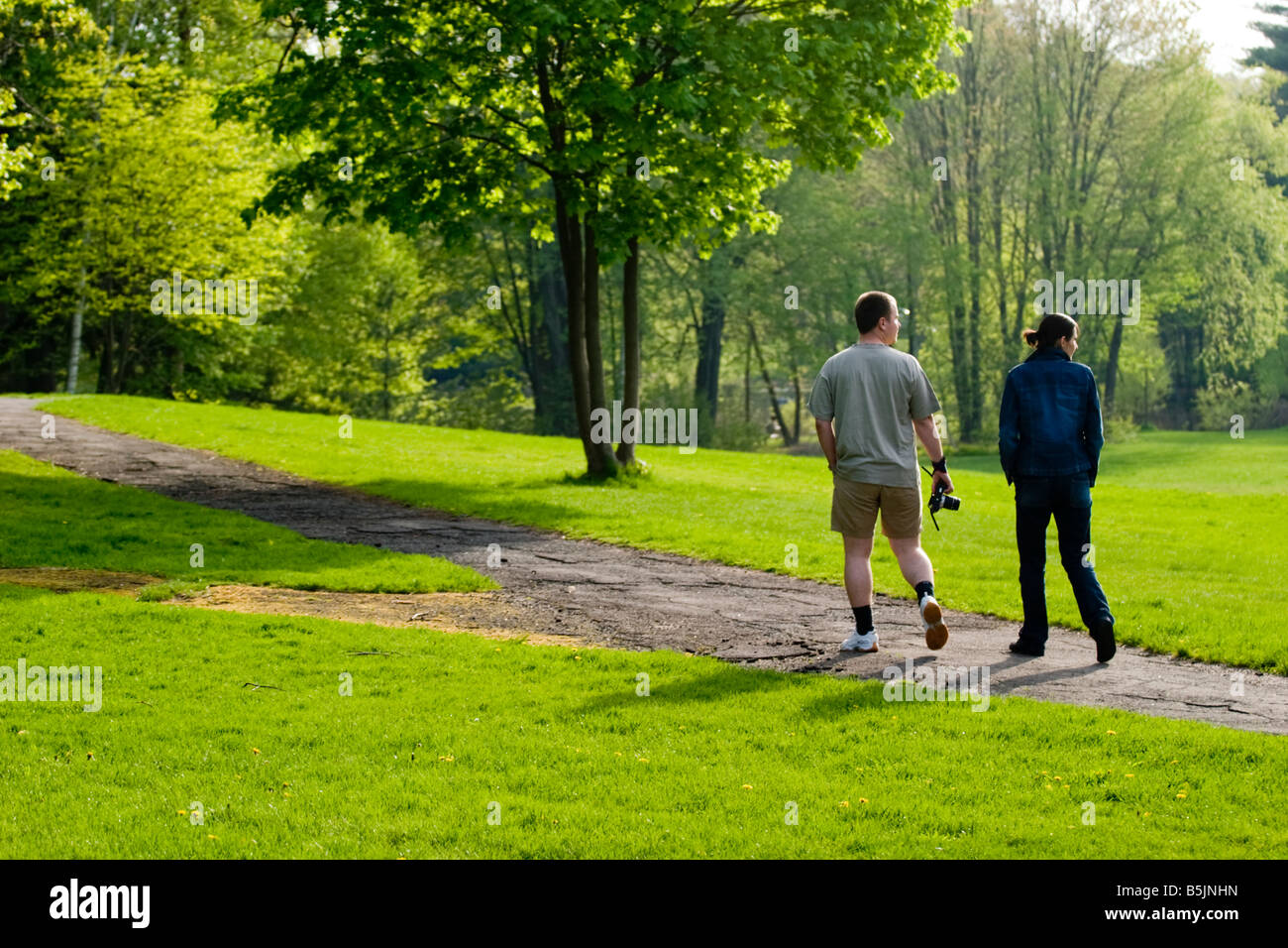 Coppia giovane camminando verso il basso di un percorso ad un parco Foto Stock