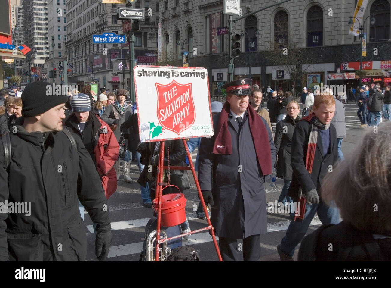 Un esercito della salvezza soldato alza il denaro per i poveri in occasione del Natale per le strade del centro cittadino di Manhattan Foto Stock