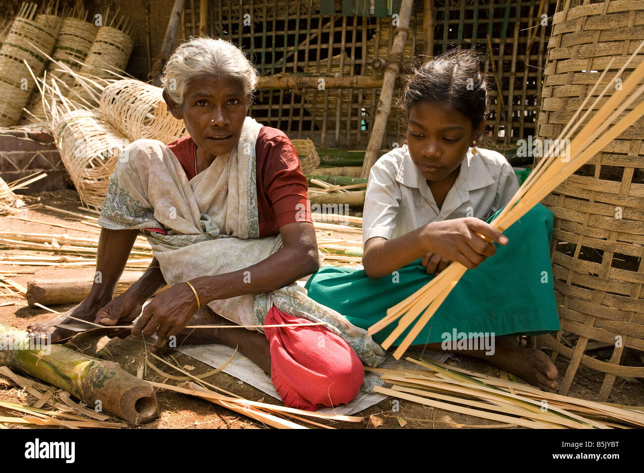 Nonnina Lokambal 57 insegna grand figlia Kokila 11 per rendere il bambù stuoie e cesti con il self help group in Velipalayam Foto Stock