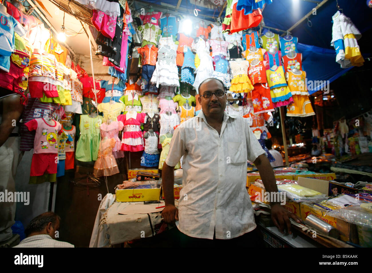 Negoziante nel suo mercato in stallo il vecchio mercato di Delhi, India Foto Stock