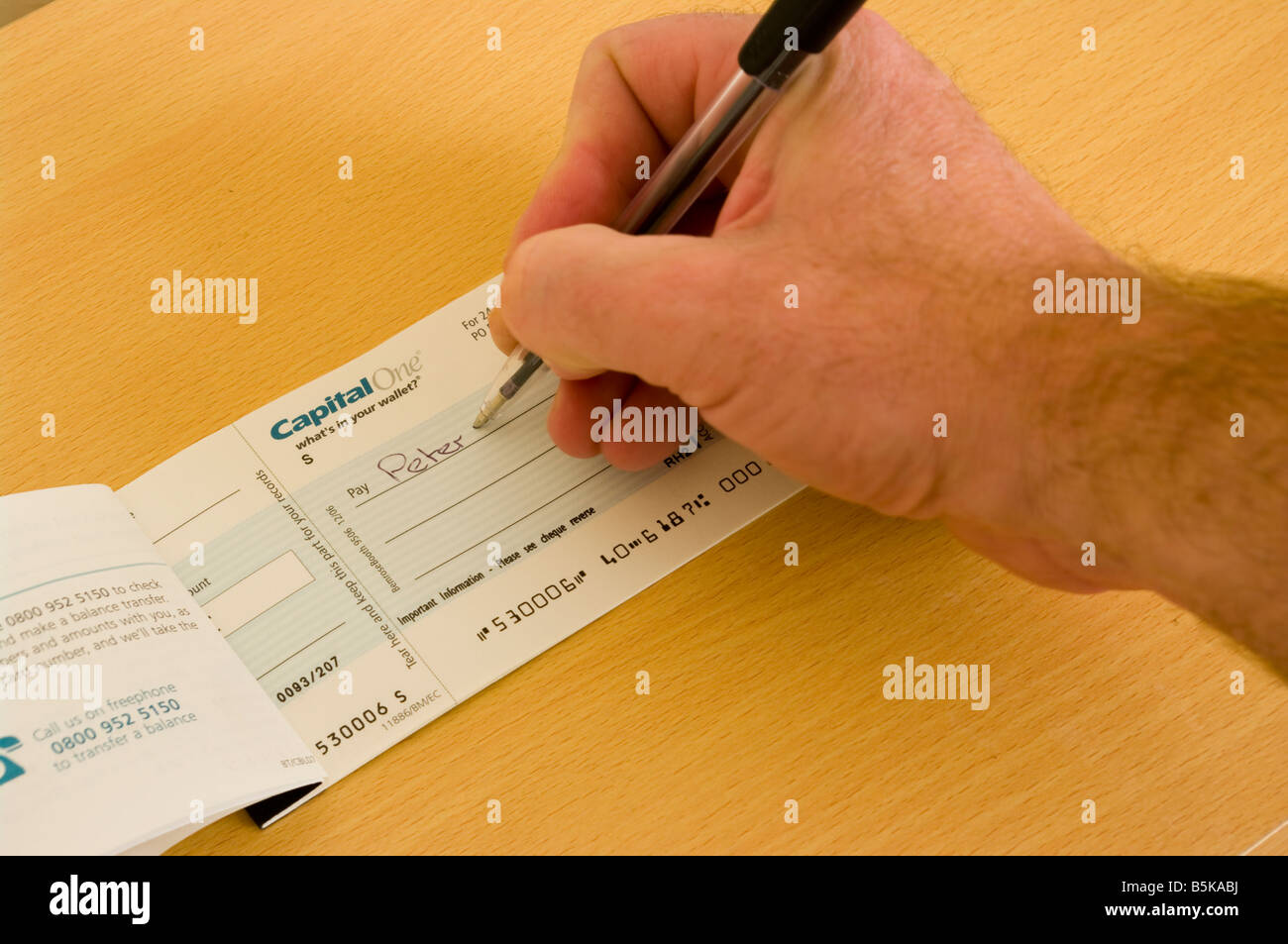 L'uomo persona scrivendo un controllo con una penna verificare libro Foto Stock