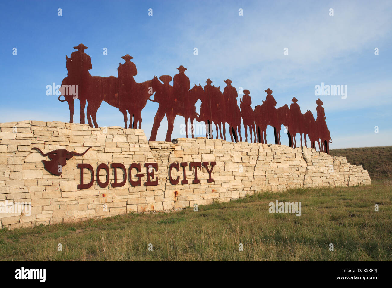 Un segno della città e la scultura all'entrata di Dodge City, Kansas, Stati Uniti d'America. Foto Stock