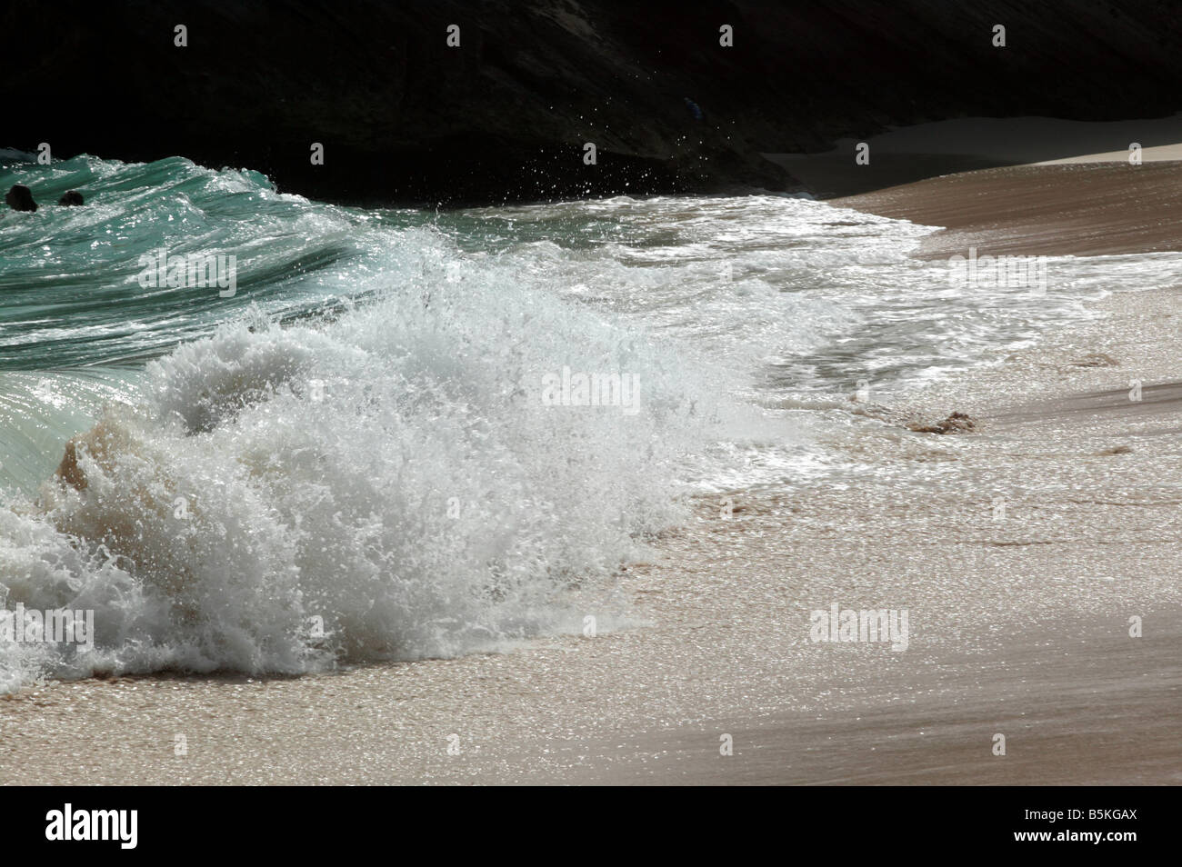 Due nuotatori sfidando heavy surf in spiaggia Stonehole, Bermuda Foto Stock