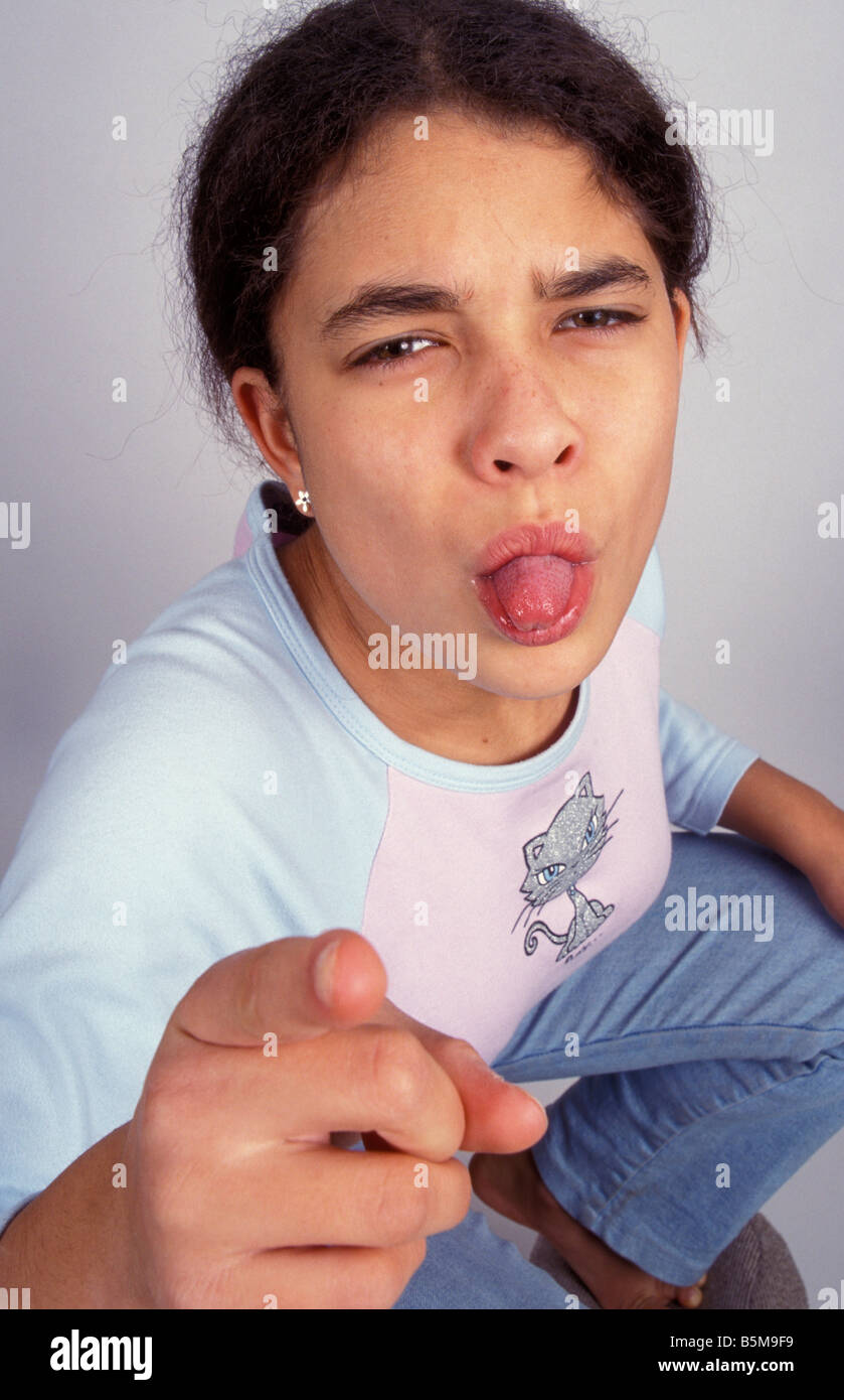 Moody bambino tirando la lingua di fuori in telecamera Foto Stock