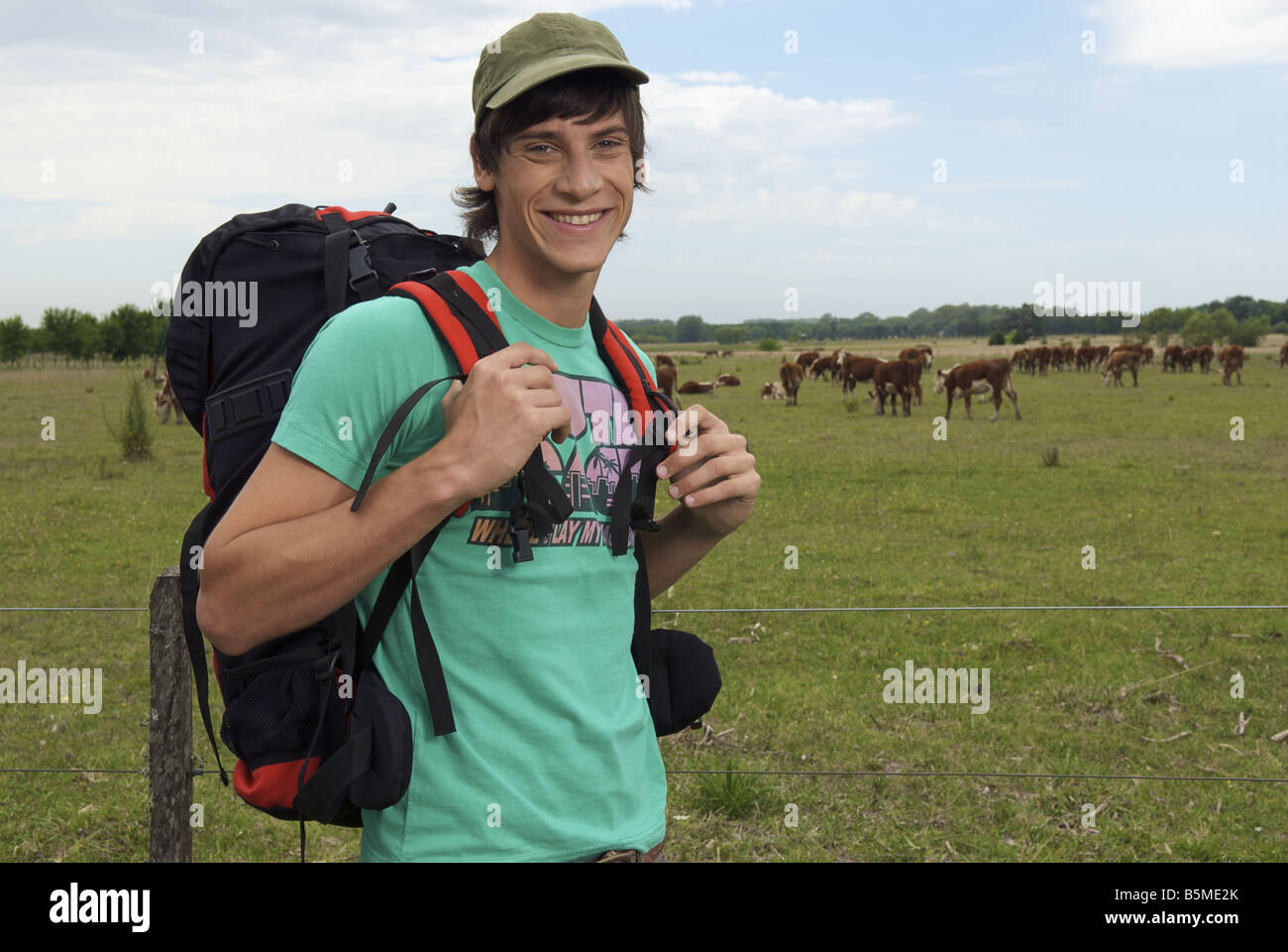 Un maschio backpacker in un pascolo del bestiame Foto Stock