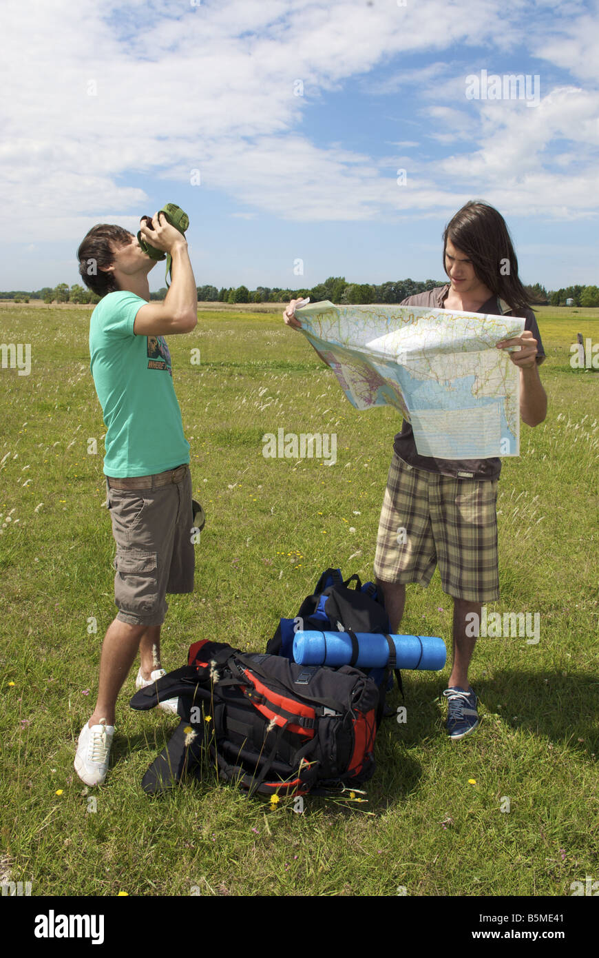 Due maschio backpackers avente un periodo di riposo in un pascolo Foto Stock