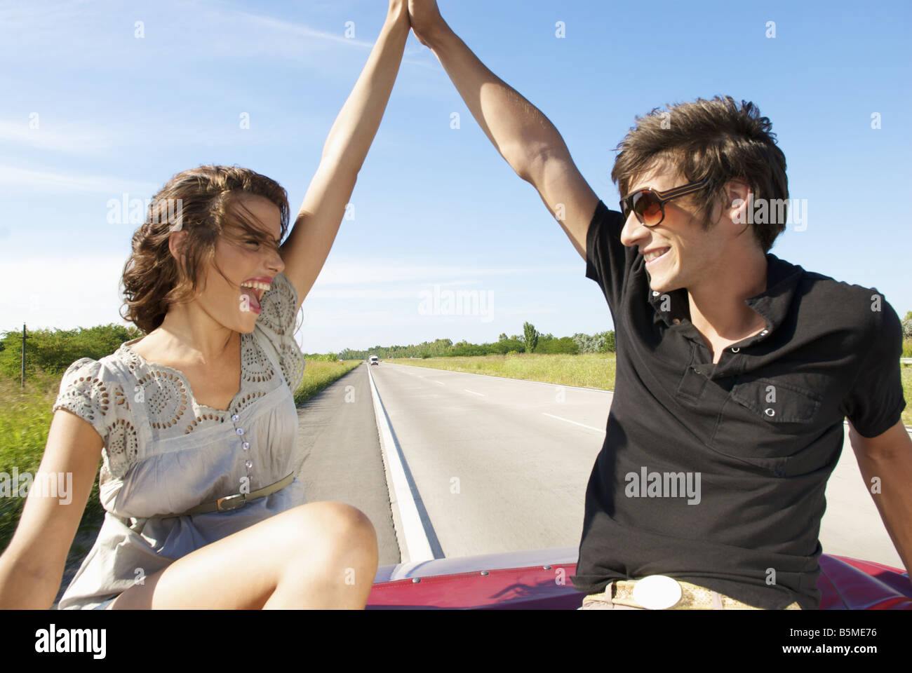Una giovane coppia seduta sul sedile posteriore di un automobile Foto Stock