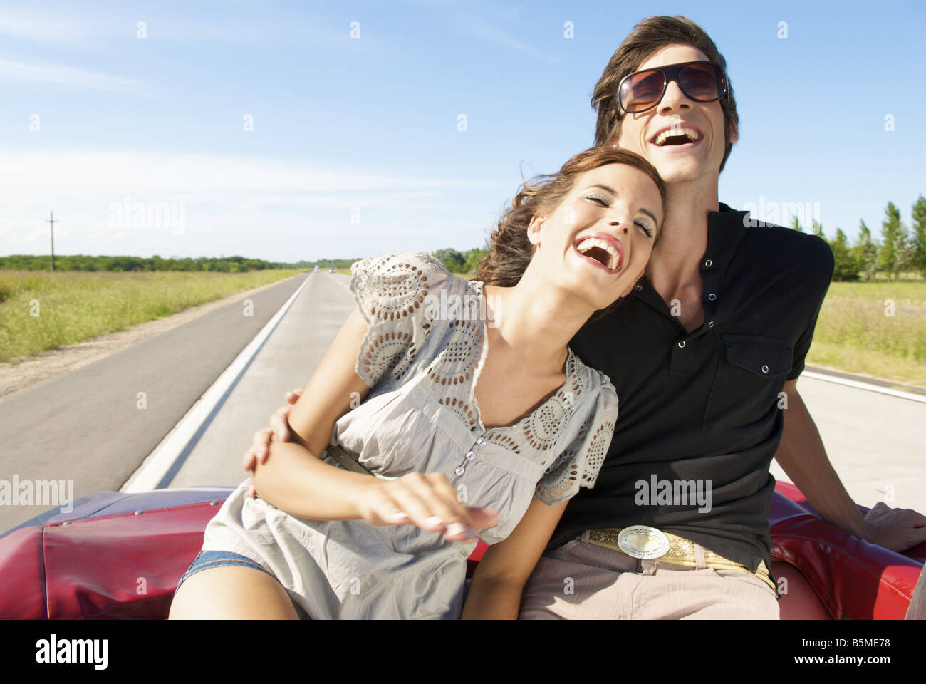 Una giovane coppia seduta sul sedile posteriore di un automobile Foto Stock
