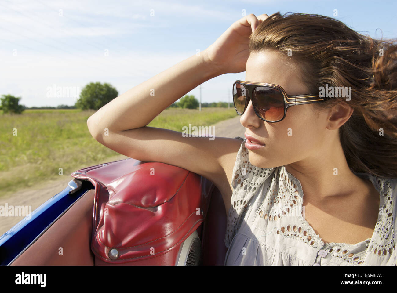 Una giovane donna seduta sul sedile posteriore di una automobile Foto Stock