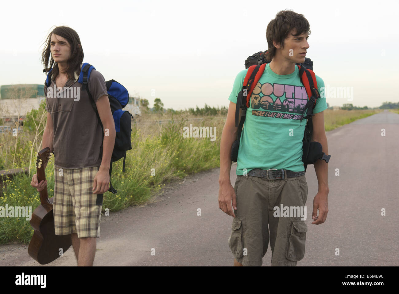 Due maschio backpackers in piedi in strada Foto Stock