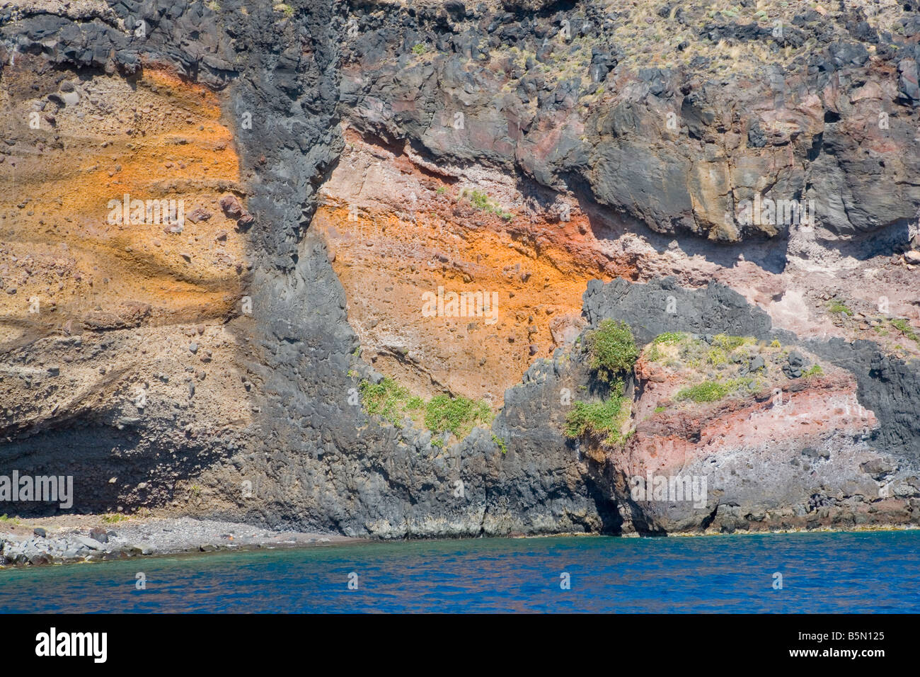 Dicco vulcanico di taglio attraverso strati colorati di antichi tufi vulcanici su Santorini Foto Stock