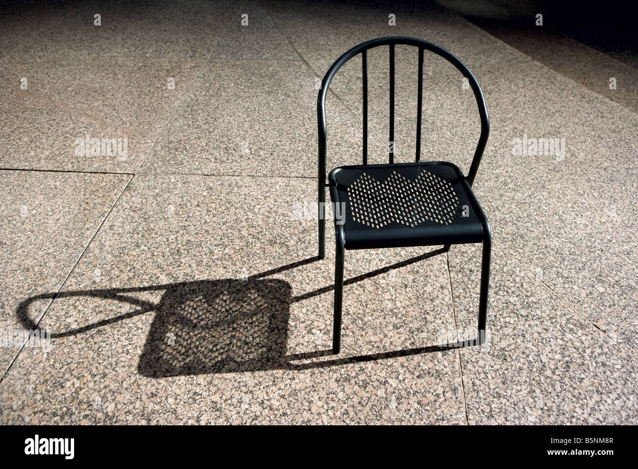 Ferro battuto patio chair in sun. Foto Stock