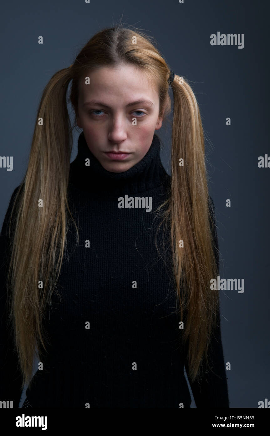 Una ragazza con i capelli in pig-tail cercando moody stroppy introverso Foto Stock