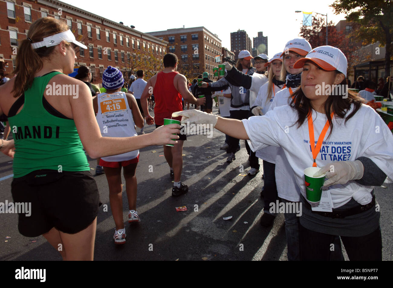 I volontari passano fuori le tazze di Gatorade in corrispondenza di una stazione di acqua in Harlem durante la trentottesima annuale di ING New York City Marathon Foto Stock