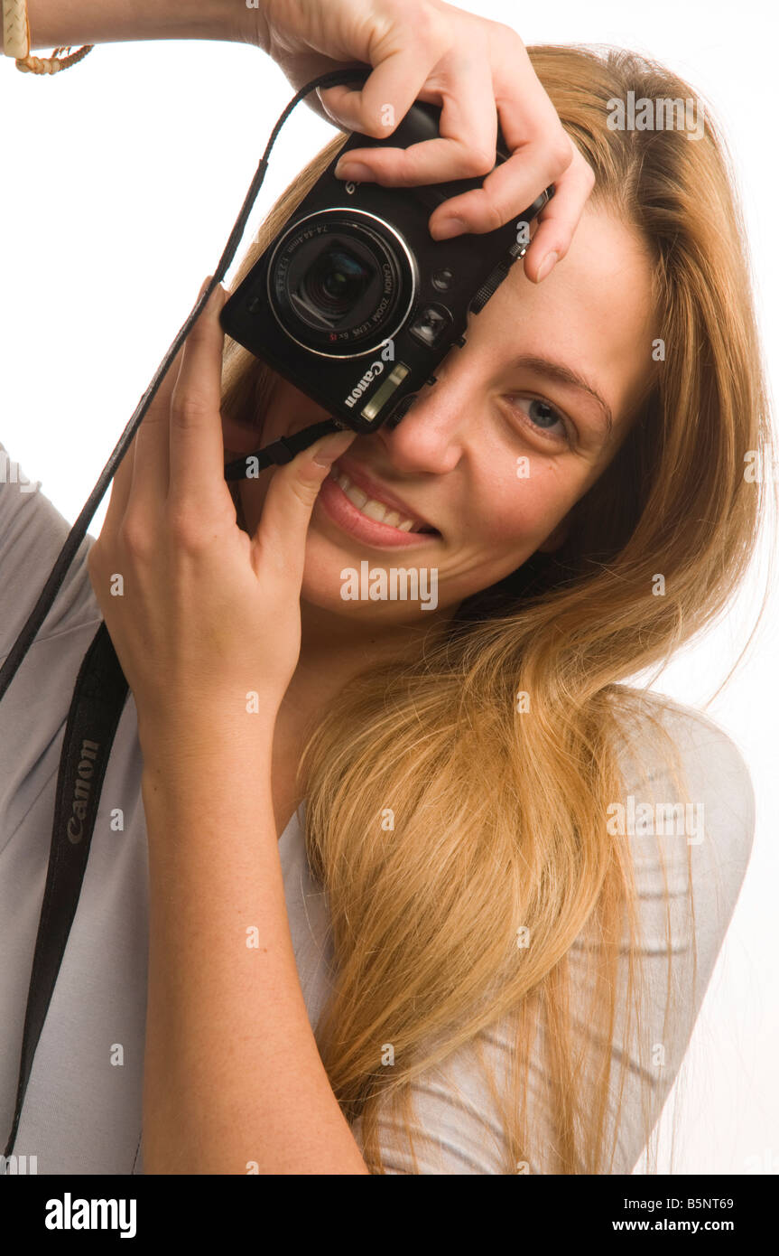 Bionda e giovane donna o ragazza adolescente di prendere una fotografia su una piccola e compatta point and shoot digital fotocamera Canon Foto Stock