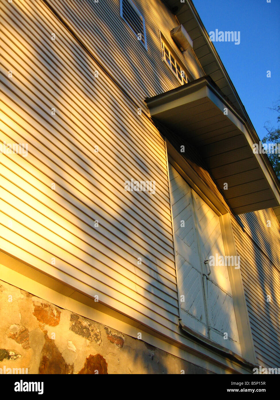 Il lato di un fienile illuminato dalla mattina presto alla luce del sole Foto Stock