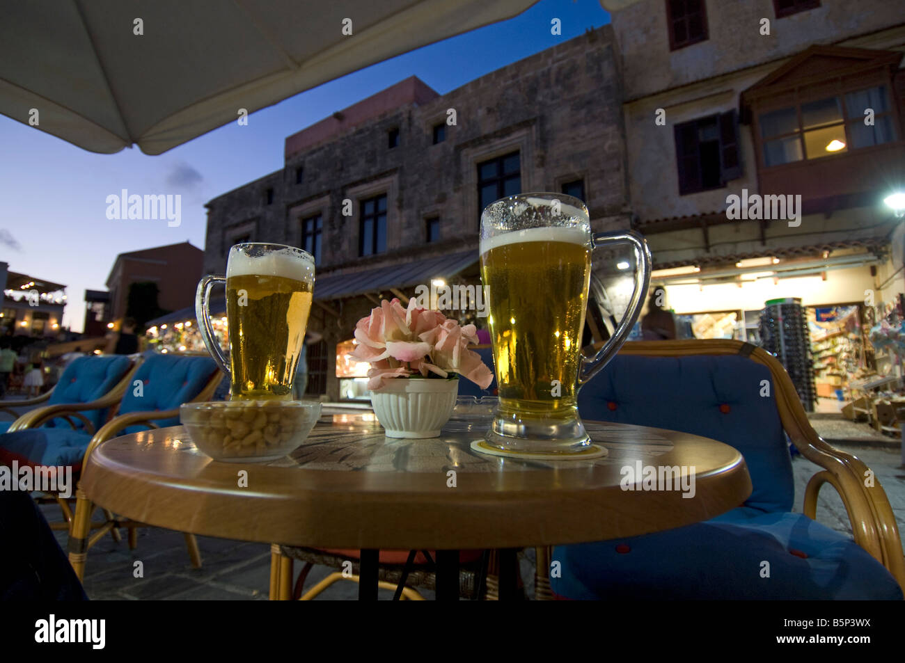 Due litri di bicchieri di birra lager di mitra su un tavolo bar nella Città Vecchia al tramonto a Rodi Grecia Foto Stock